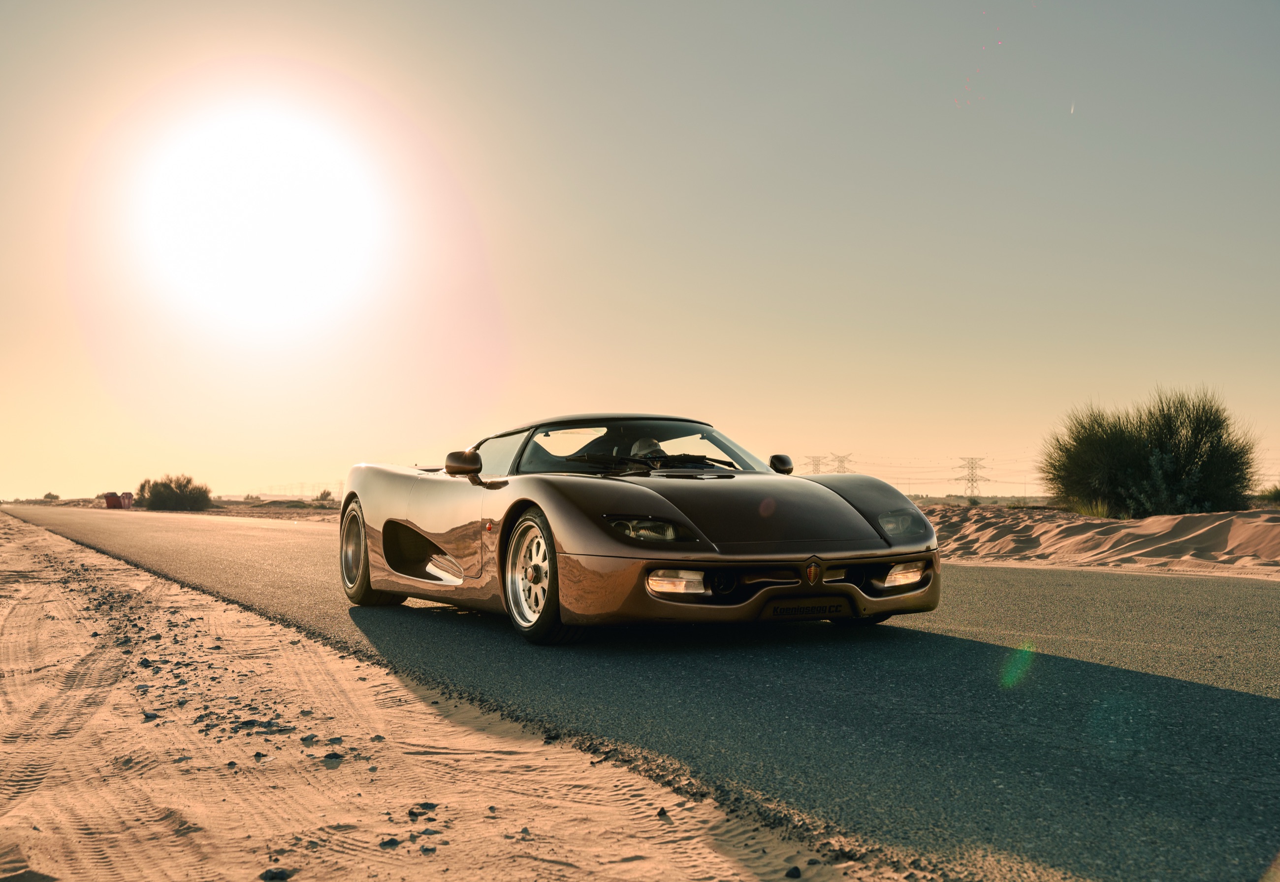 The Koenigsegg CC prototype on a desert road at sunset